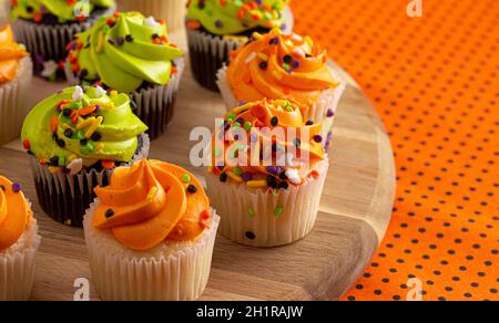 Halloween Themed Cupcakes with Sprinkles on an Orange and Black Table Stock Photo