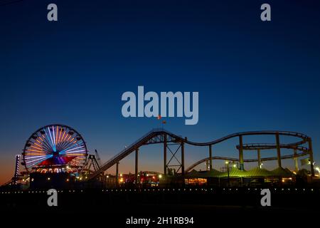 Ferris wheel and roller coaster at dusk, Pacific Park, Santa Monica Pier, Santa Monica, Los Angeles, California, USA Stock Photo