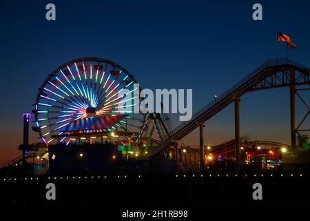 Ferris wheel and roller coaster at dusk, Pacific Park, Santa Monica Pier, Santa Monica, Los Angeles, California, USA Stock Photo