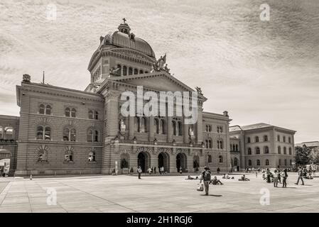 Bern, Switzerland - May 26, 2016: People are resting on the square in front of the Swiss Parliament Building (Bundesplatz) in Bern, Switzerland. Sepia Stock Photo