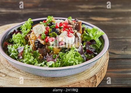 Eggplant salad with feta cheese, pomegranate and currants in a coffee marinade. French gourmet cuisine Stock Photo
