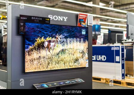 POZNAN, POL - FEB 24, 2021: Modern flat-screen TV set by Sony put up for sale in an electronics store Stock Photo
