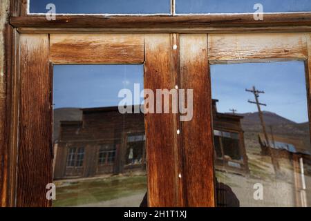 Reflection in front door of Wheaten and Hollis Hotel, Bodie Ghost Town, Bodie Hills, Mono County, Eastern Sierra, California, USA Stock Photo