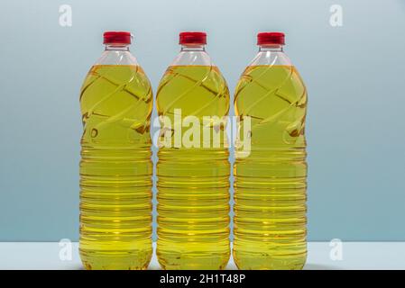 Bottles of edible soy oil on blue background. Olive oil for salads and cooking in general. Soybean oil is extracted from soybean seed and is used as a Stock Photo