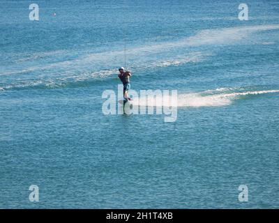 Riding a wakeboard at sea on a reversible winch. Caspian Sea. Kazakhstan. Aktau city. 08 September 2019 year. Mangistau region. Stock Photo