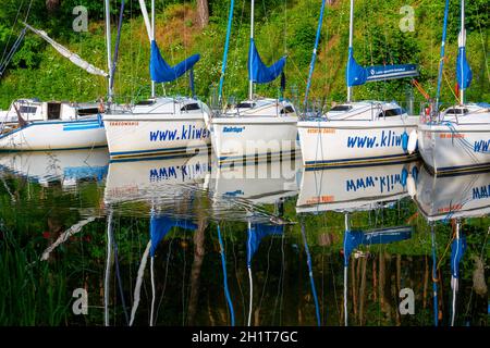 Masuria, Ruciane-Nida, Poland - June 24, 2020: Yacht marina on the Masurian Lakes, yachts moored at the shore, reflection in the water Stock Photo