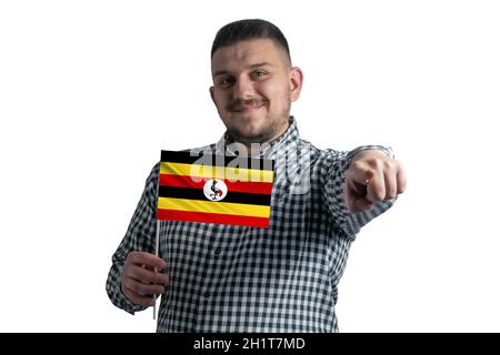 White guy holding a flag of Uganda and points forward in front of him isolated on a white background. Stock Photo