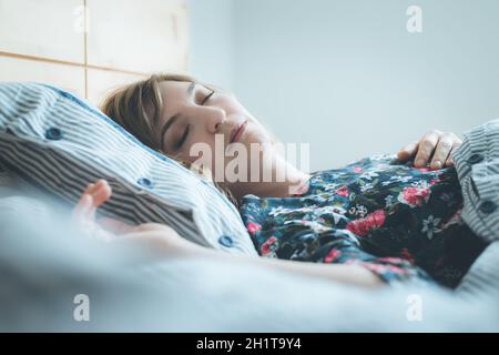 Young woman sleeping peacefully in her bedroom, day Stock Photo