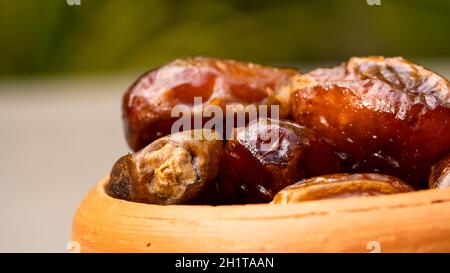 Dates in clay bowl on background. dried dates fruit. Stock Photo