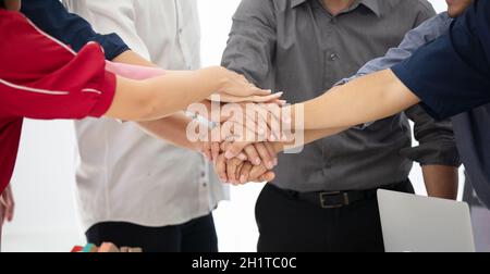 Diverse group of people joining hands in unity, support and team work gesture.Close up shot of hands, Team handshake Stock Photo