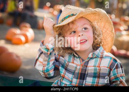 Adorable Little Boy Wearing Cowboy Hat at Pumpkin Patch Farm. Stock Photo