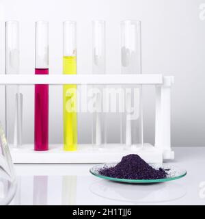 Cosmetic chemicals ingredient on white laboratory table. KMnO4 on chemical watch glass. Potassium Permanganate Liquid and Nickle chloride liquid in te Stock Photo