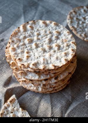 Thin round crispbreads baked with wheat, rye and barley on textile background Stock Photo