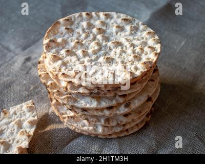 Thin round crispbreads baked with wheat, rye and barley on textile background Stock Photo