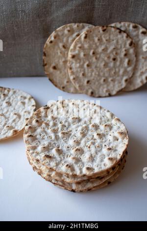 Thin round crispbreads baked with wheat, rye and barley on white and textile background Stock Photo