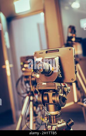 Film camera on a tripod in a television broadcasting studio, spotlights and equipment Stock Photo