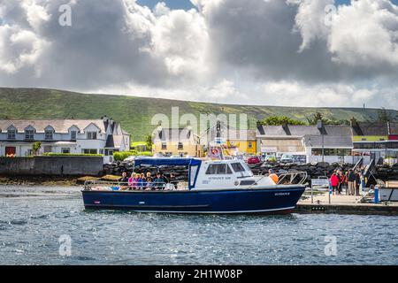 Portmagee, Ireland, August 2019 Group of tourists boarding a cruise boat to visit Skellig Michael island where Star Wars were filmed, Ring of Kerry Stock Photo