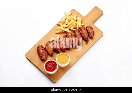 Barbecue chicken wings on wooden tray and sauce on wooden board. Isolated on a white background. Shot for restaurant menu Stock Photo