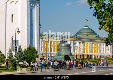 Moscow, Russia - September 15, 2018: Tourists visiting the Kremlin. Inside there is a giant bell in front of a cathedral Stock Photo