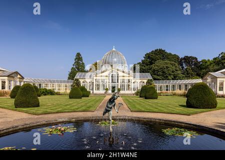 Statue of winged Mercury and the Great Conservatory in the gardens of Syon House, built by Charles Fowler in 1826, Syon Park, West London, England, UK Stock Photo