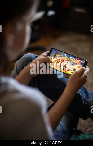 Bucharest, ROMANIA - May 10, 2021: Illustrative editorial concept image of a child playing Clash of Clans game on a mobile phone. Stock Photo