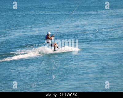 Riding a wakeboard at sea on a reversible winch. Caspian Sea. Kazakhstan. Aktau city. 08 September 2019 year. Mangistau region. Stock Photo