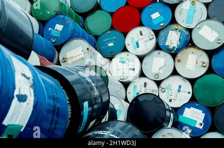 Old chemical barrels. Blue, red, and green chemical drum. Steel tank. Hazard chemical barrel with flammable liquid warning label. Industrial waste. Is Stock Photo