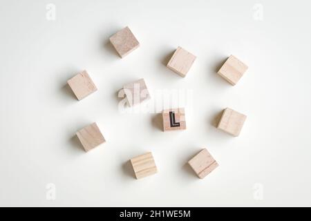 Wood cubes on white background with one L letter on one of the cubes. Leadership concept. Stock Photo