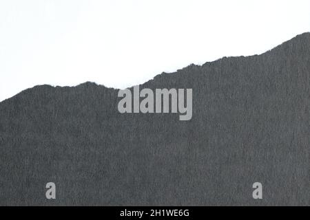 Ripped white paper on black background. Space of advertising copy. Stock Photo