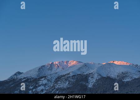 Sunrise view of a snow mountain and forest in Kanas, Xinjiang province, China. Stock Photo