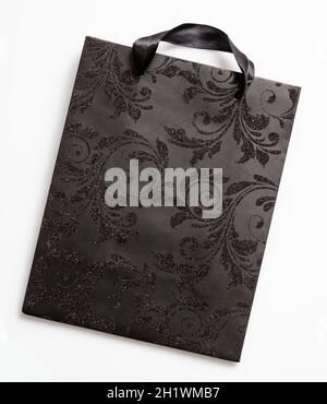 Black Friday concept. Black shopping bag with glitter decoration isolated on white background, top view, Luxury purchase, holiday gift Stock Photo