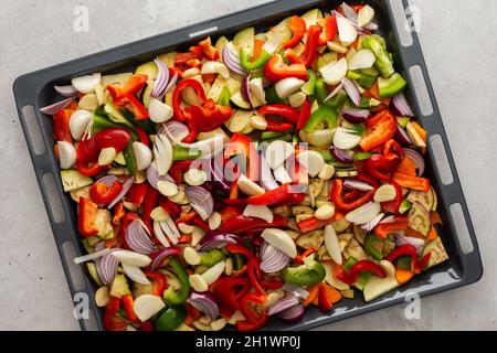 Fresh assorted autumn cut vegetables on a baking sheet ready to roast in the oven Stock Photo