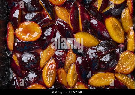 Caramelized in sugar syrup pieces of plums, food background. Close up, flat lay Stock Photo