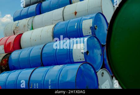 Old chemical barrels stack. Red, green, and blue chemical drum. Steel tank of flammable liquid. Hazard chemical barrel. Industrial waste. Empty chemic Stock Photo