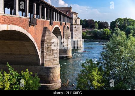 Pavia, Lombardy, Italy - July 8, 2019: Ponte Coperto or Covered Bridge or the Ponte Vecchio, the famous stone arch bridge over the Ticino River. Stock Photo