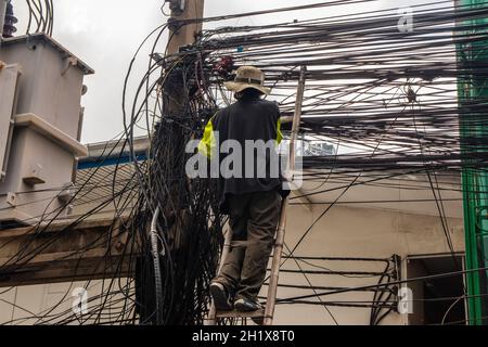 An electrician at his daily work in Bangkok Thailand Southeast Asia Stock Photo