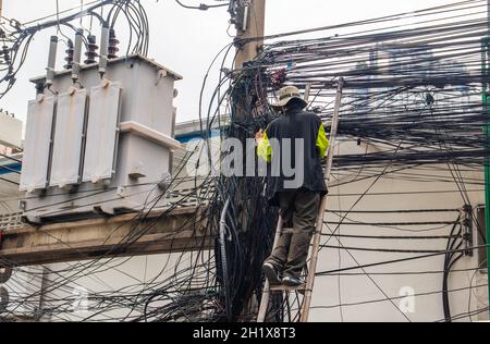 An electrician at his daily work in Bangkok Thailand Southeast Asia Stock Photo