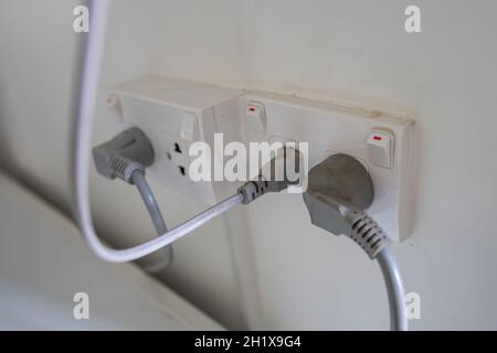 Power cable electric plug on wall at house. Stock Photo