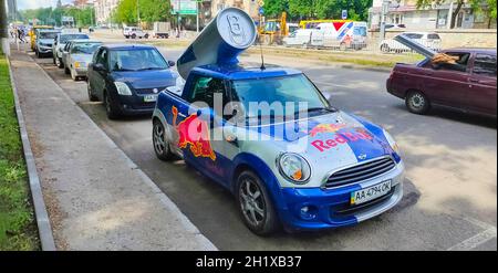 Kiyv, Ukraine - August 2, 2020: Small car covered with the Red Bull advertisement at the city street. Stock Photo