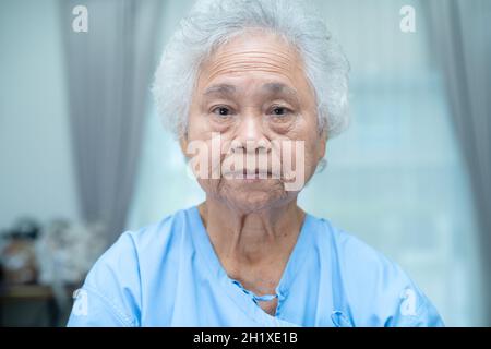 Asian senior or elderly old lady woman patient bright face while sitting in  nursing hospital ward, healthy strong medical concept. Stock Photo