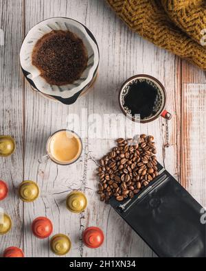 Coffee beans, coffee capsules, espresso and filter coffee (V60) on table Stock Photo