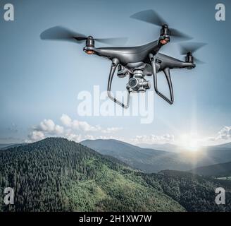 Dark drone flying above mountains. Stock Photo