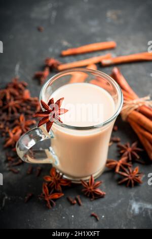 Tasty tea with milk and spices on the rustic background. Selective focus. Shallow depth of field. Stock Photo