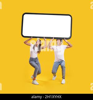Couple holding heavy white empty smartphone screen Stock Photo