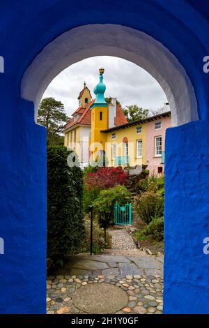 Portmeirion village, Gwynedd, North Wales - view of Chantry and Chantry row cottages through archway - colourful buildings in tourist village Stock Photo