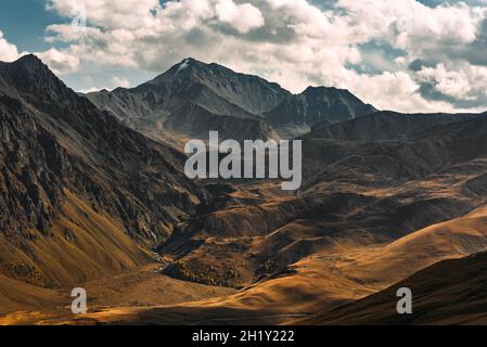Incredibly beautiful mountain landscape. Mountain peaks in the sun. Panoramic view of the autumn mountains. Landscape with views of mountain valleys.