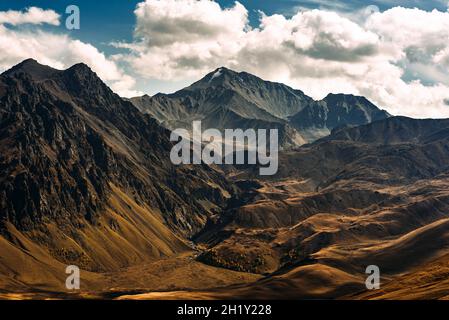 Incredibly beautiful mountain landscape. Mountain peaks in the sun. Panoramic view of the autumn mountains. Landscape with views of mountain valleys.