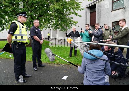 Police Scotland Chief Inspector Derrick Johnston, area commander for South Ayrshire (left) and Scottish Fire and Rescue Service Area Commander, Ian McMeekin speak to the media at the incident in Gorse Park, Kincaidston, where two adults and two children were taken to hospital following a large explosion at a house on Monday. Picture date: Tuesday October 19, 2021. Stock Photo