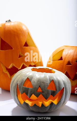 Composition of three halloween carved pumpkins with copy space on white background Stock Photo