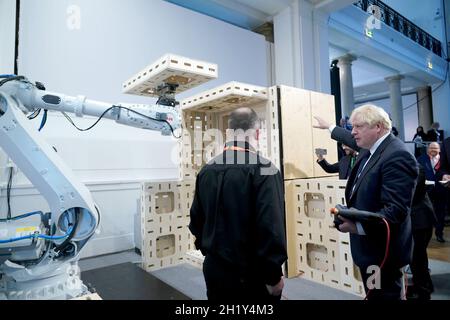 Prime Minister Boris Johnson operating a robot arm at the Auar (Automated Architectire) stand during a visit to the Innovation Zone of the Global Investment Summit at the Science Museum, London. Picture date: Tuesday October 19, 2021. Stock Photo